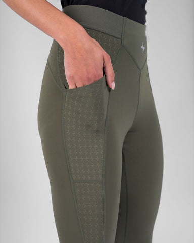 A woman showcasing the pocket feature on a pair of Olive modest THABYA LEGGINGS by qynda.