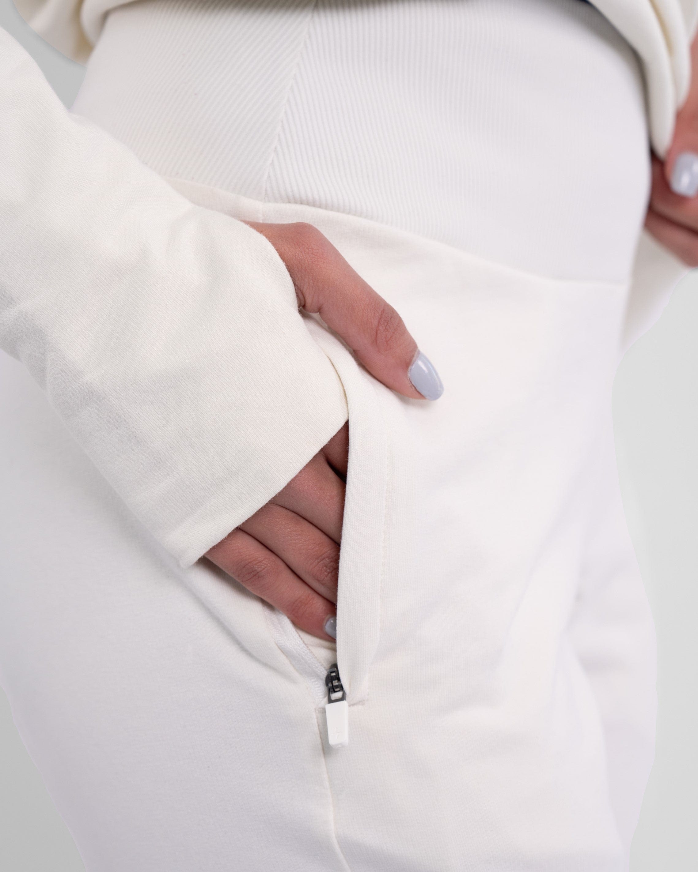 A close-up of a woman in an Off White CANTARA PANTS outfit with their hand in the pocket, showcasing a modern and minimalist fashion style by qynda.