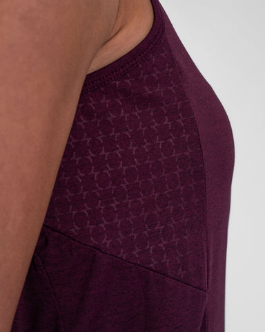 Close-up of a textured purple fabric with a subtle pattern, focusing on the sleeve seam and shoulder area of a cooling tank top.