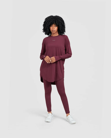 A model stands confidently in a modest maroon MOD LONG SLEEVE T-SHIRT by Qynda.