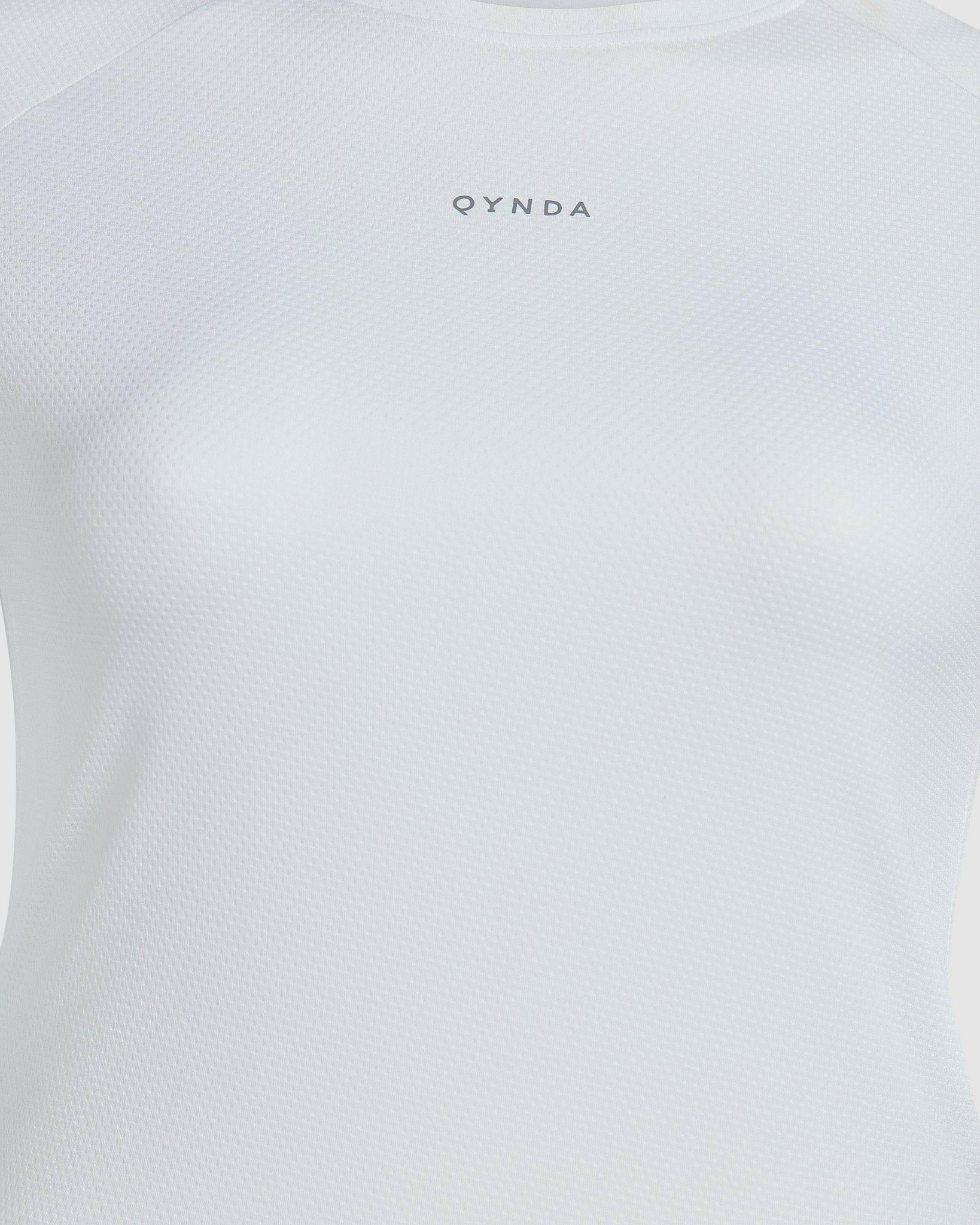 Close-up of a white short sleeve t-shirt designed for running sports, with a textured fabric enhancing breathability and the brand name "qynda" printed at the chest area.