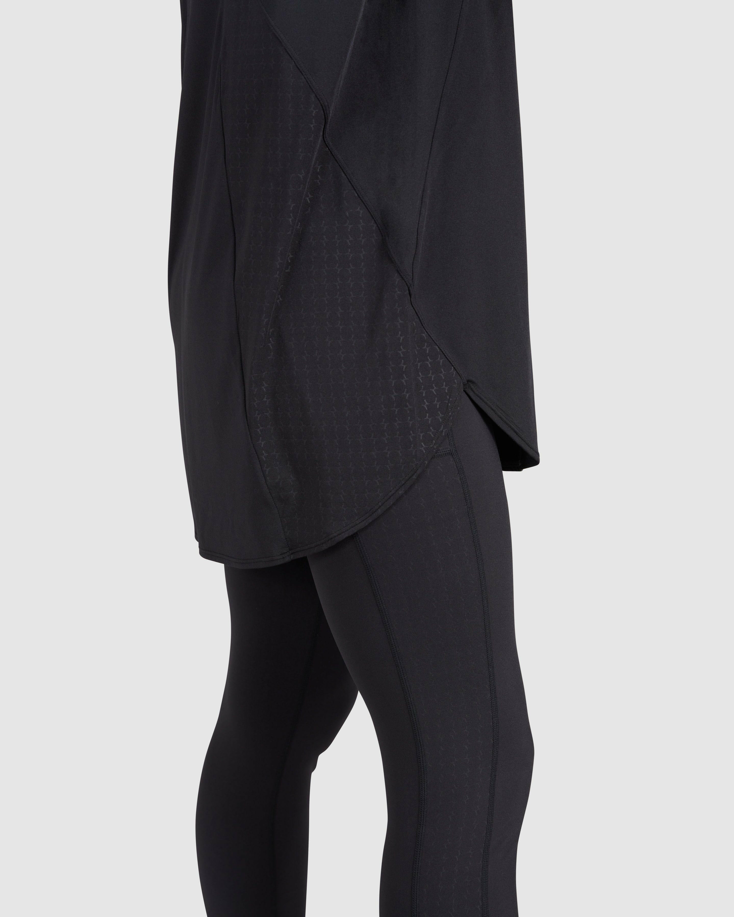 Close-up side view of a model wearing modest Black MOD LONG SLEEVE T-SHIRT by Qynda with a unique textured pattern, crafted from super light material. 